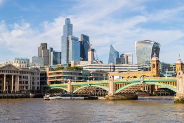 LONDON, İngiltere - 6 Temmuz 2023: Thames Nehri üzerinde gün boyunca Londra 'nın merkezinde bir Uber Boat. Birçok bina görülebilir..