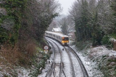 Londra, İngiltere - 8. MAR 2023: Karlı bir kış günü Londra 'da demiryollarında bir tren.