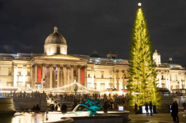 Londra, İngiltere - 6 Aralık 2022: Londra 'daki Trafalgar Meydanı. Noel ağacı, market tezgahları ve çeşme gösteriliyor. İnsanlar görülebilir..
