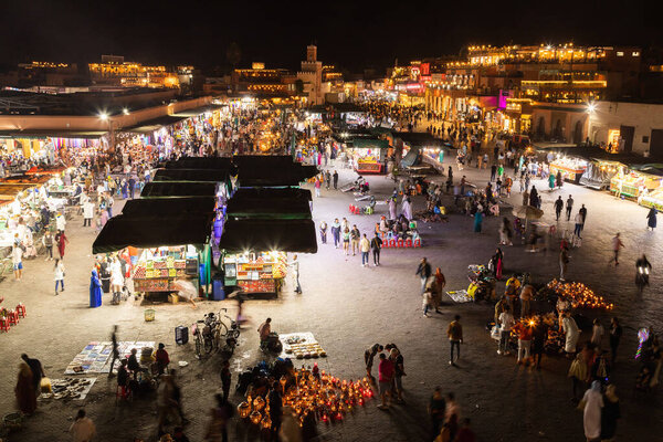 MARRAKESH, MOROCCO - 3RD NOV 22: Aerial views over Jemaa el-Fna in the Medina of Marrakesh at night. Lots of people can be seen around the market.