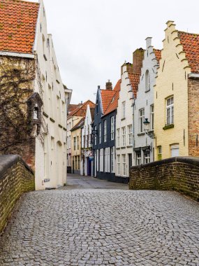 Kışın Bruges sokakları boyunca binaların tarzını gösteren bir manzara. Metin için boşluk var.