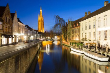 Kışın, Bruges 'deki Dijver Kanalı ve caddesi boyunca bir manzara. Leydi Bruges Kilisesi uzaktan görülebiliyor. Metin için boşluk var.