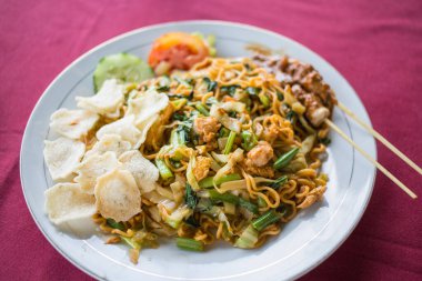 Bali 'de tipik bir yemek, erişte, sebze, karides kraker ve tavuk satay.