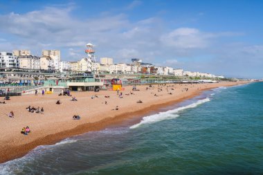 BRIGHTON, İngiltere - 11 Mayıs 2023: İlkbaharda İngiltere 'de Brighton Sahili' nin bir kısmı. Sahilde dinlenen bir sürü insanı gösteriyor.