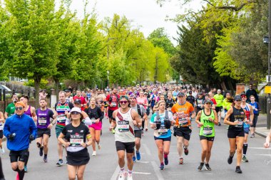 LONDON, UK - 21ST APRIL 2024: Groups of people running in the London Marathon 2024 mass run clipart