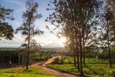 Rwanda - 4. NOV 23: kırsal kesimlerde gün batımında yollar, insanlar ve binalar