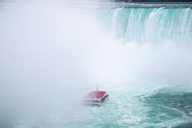 NIAGARA FALLS, CANADA - 27TH JUL 2022: A large group of people on the Niagara City Cruises boat ride around the horseshoe falls in Niagara Falls. clipart