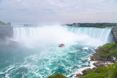 NIAGARA FALLS, CANADA - 27 Temmuz 2022: Niagara Şehir Gezileri 'nde bir grup insan Niagara Şelalesi' nde at nalı etrafında tekne turu yapıyor..