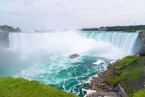 NIAGARA FALLS, CANADA - 27 Temmuz 2022: Niagara Şehir Gezileri 'nde bir grup insan Niagara Şelalesi' nde at nalı etrafında tekne turu yapıyor..