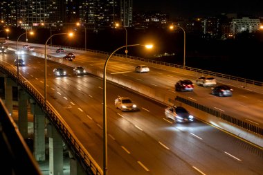 The Toronto Gardiner Expressway in Toronto at night. The cars can be seen on the road. clipart