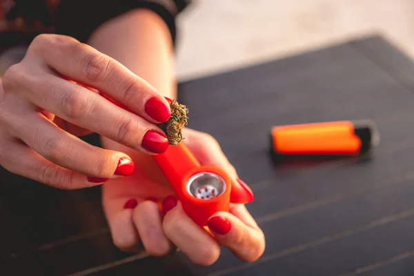 Hands Red Nails Putting Weed Bud Marijuana Plastic Orange Pipe — Stock Photo, Image