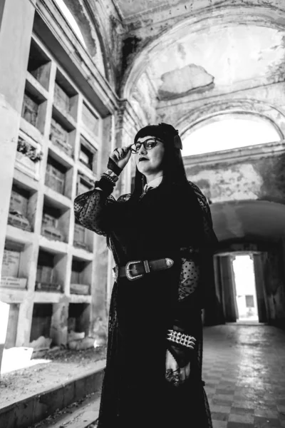黑色哥特式女人 身穿黑色衣服 住在古旧废弃的大陵墓中 风格新颖 有壁龛 拱门和阳光 黑白相间 — 图库照片