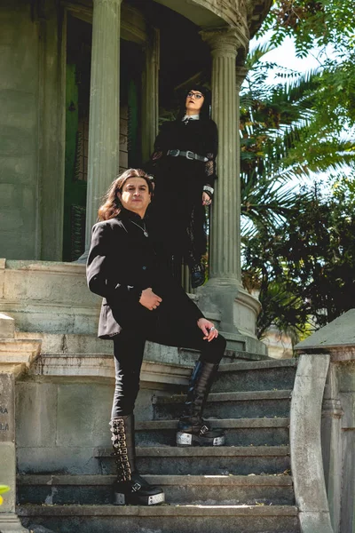 stock image Dark gothic couple in large ancient abandoned mausoleum in neoclassical style with columns and stairs in the forest