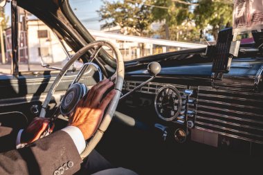 Öğleden sonra şık bir düğün arabasına binen yaşlı bir adamın elleri.