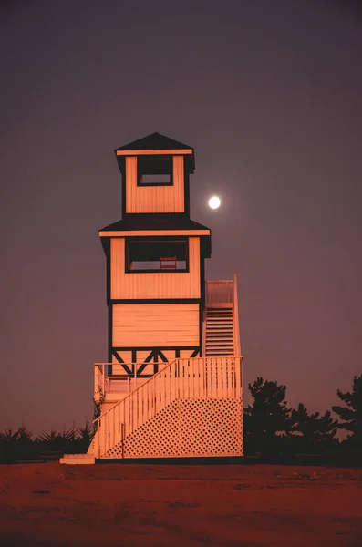 紫色落日的天空下 有满月的木制大白塔 — 图库照片