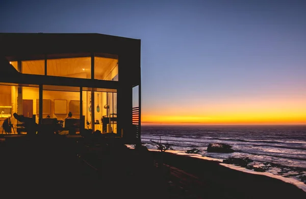 Tranquillità Oceanica Silhouette Casa Nella Scogliera Con Luci Calde Luna — Foto Stock