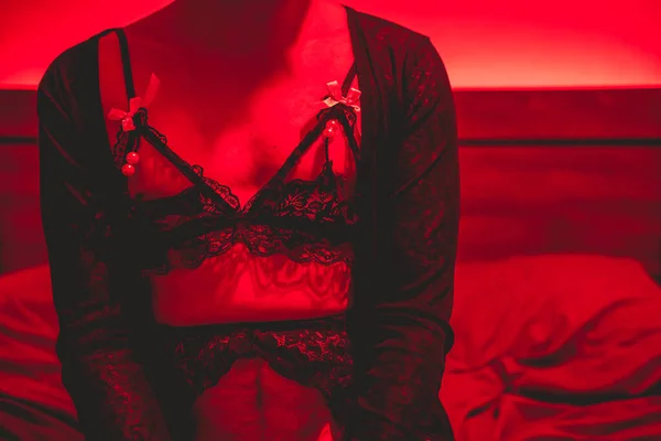 Stock image Bending gender norms: in bed with a non-binary femboy in seductive black lingerie and passionate red light