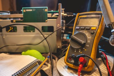 Elektronik uzmanlık: çoklu metre, açık elektronik ekipman ve masada bir defter