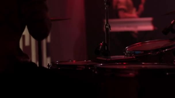 精力的なドラムビート カラフルなライトの下でコンサートで活気のあるライブパフォーマンスを提供する若いラティノのドラマーの手とドラムの閉鎖 — ストック動画