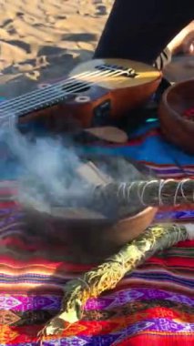 Gizemli And yolculuğu: Peru battaniyesi, Charango, şifalı otlar, doğal malzemeler, kristaller ve çölde yanan kutsal ahşap tütsü.
