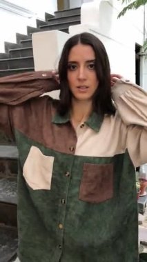 Latin güzelliği ve cazibesi: güzel esmer manken moda görünümlü büyük boy pamuklu gömlekli şehir sokaklarında hareketler yapan