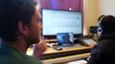 Yaratıcı müzik işbirliği: genç müzisyen, müzik sanatçılarının stüdyoda büyük kulaklıklarla yaptıkları gibi melodilerden hoşlanıyor
