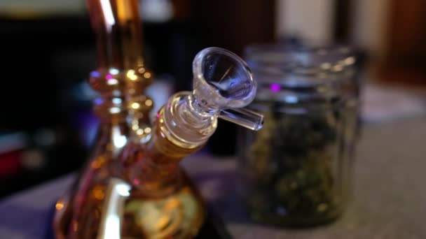 大麻の経験をリラックスさせる 透明なガラスのマリファナのウォーターベンと緑の鍋が付いているガラス瓶の閉鎖 — ストック動画