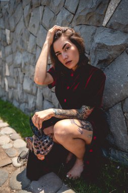 Egzotik baştan çıkarma: dövmeli seksi esmer kadın kıpkırmızı ipek Çin elbisesi içinde ve duvarda tavşan maskesi var.