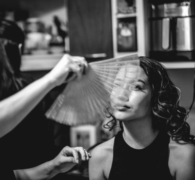 Hazırlığın güzelliği: bir makyöz güzel ve genç bir esmer modeli fotoşop için hazırlıyor (siyah ve beyaz olarak))