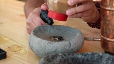 Elleri ustalıkla alev alev yanan şeker ve tarçın üzerine pürmüzle