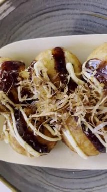 Lezzetli Japon lokumu: geleneksel takoyaki 'ye yakın çekim, lezzetli soslu bir sokak yemeği, kremalı mayonez, ve dans eden bonito taneleri (katsuobushi pulları))