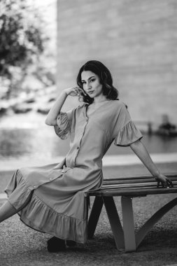Güzellik ve Latin cazibesi: Parkta güneşli bir günde şık görünümlü güzel esmer model (siyah ve beyaz))