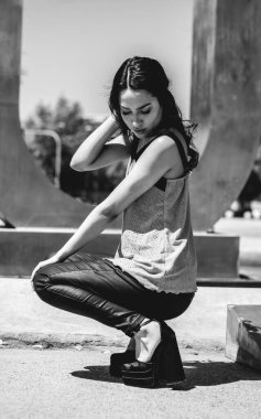 Güzellik ve Latin cazibesi: Parkta güneşli bir günde şık görünümlü güzel esmer model (siyah ve beyaz))