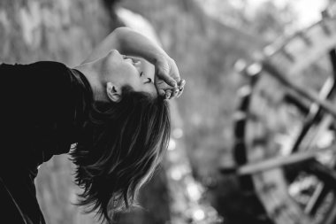 Egzotik baştan çıkarma: dövmeli seksi Latin esmer kadın kırmızı ipek Çin elbisesi içinde halka açık bir parkta ahşap bir su çarkının önünde (siyah beyaz))