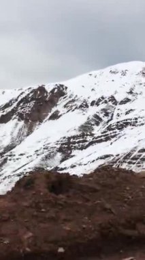 Fısıldayan kış yolculuğu: hareketli bir arabanın sıcaklığından kar kaplı dağların büyüleyici manzarası