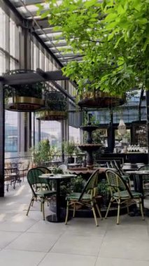 Yeşillik ve cam mimarisi olan modern lüks bir restoran.