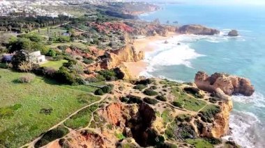 Portekiz 'in Albufeira, Algarve, Portekiz yakınlarındaki güney kıyısındaki altın uçurumların ve kaya oluşumlarının hava aracı görüntüsü..