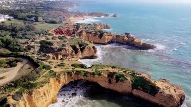 Portekiz 'in Albufeira, Algarve, Portekiz yakınlarındaki güney kıyısındaki altın uçurumların ve kaya oluşumlarının hava aracı görüntüsü..
