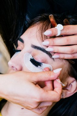 Tanınmayan güzellik uzmanlarının yüksek açılı görüntüsü onları kıvırcık ve büyük yapmak için sahte kirpikleri tarar. Konsept: güzellik ve refah