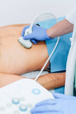 Tanınmayan insanların olduğu bir hastanede kullanılan ultrason cihazını kapat. Teşhis teknolojisi ve klinik ekipmanlar. İnsan eli ve insan vücudu