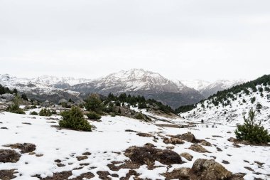 Ibon de Piedrafita, Aragon Pyrenees 'de (İspanya) kışın karla kaplı manzaralı donmuş bir göl. Aile dostu ve ulaşılabilir bir doğa noktası, boş bir yürüyüş ve kolay bir gezinti için mükemmel.