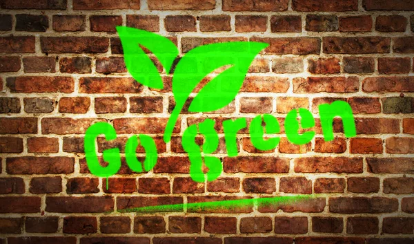 Go green spray painted inscription on the brick wall. Urban abstract artwork. Graffiti art concept of eco friendly ecology and environment. Airbrush paint with text template in hand illustration.