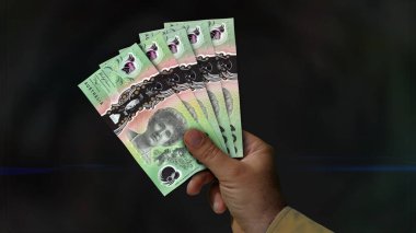 Australia Dollar pile of money in hand 3d illustration. AUD banknotes background concept of finance, economy crisis, inflation and business.