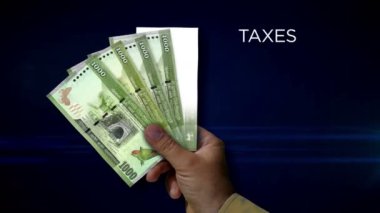 Sri Lanka Rupisi kağıt para tutuyor. LKR banknotlarının hayranı. Gelir kaybı, yaşam, vergi, kredi ve para kaybı metaforu.