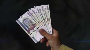 Özbekistan Sum 'un parası duruyor. Eldeki banknotların hayranıyım. UZS kağıt para. Gelir, başarı, iş, vergi, ekonomi ve finans kavramı.