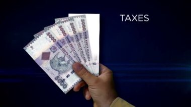 Tanzanya şilini elinde tutuyor. Eldeki banknotların hayranıyım. TZS kağıt para. Gelir, başarı, iş, vergi, ekonomi ve finans kavramı.