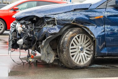 Lindesnes, Norveç - 07 Ağustos 2022: Sol ön tekerlekte geniş çaplı hasar bulunan koyu mavi bir Ford aracın ayrıntıları.