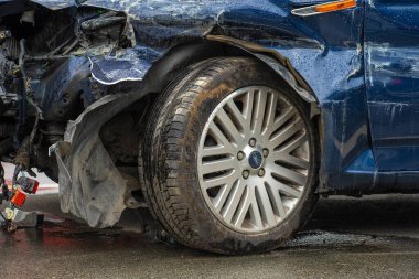 Lindesnes, Norveç - 07 Ağustos 2022: Sol ön tekerlekte geniş çaplı hasar bulunan koyu mavi bir Ford aracın ayrıntıları.