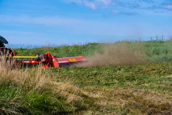 stock image Gothenburg, Sweden - september 06 2022: Tractor cutting the grass in a field at summer.