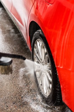 Kırmızı bir arabayı yıkamak ve temizlemek..